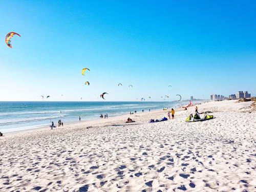 a group of people on a beach flying kites at Heaven on Earth - Blouberg Beachfront Self-catering Apartment in Bloubergstrand