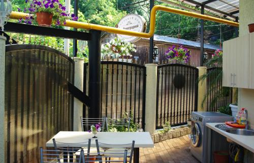 a patio with a table and chairs and a fence at Guest House on Vinogradnaya in Sochi