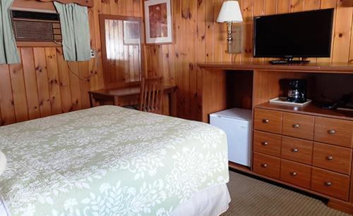 a bedroom with a bed and a flat screen tv at Gorham Motor Inn in Gorham