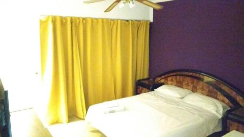 1 dormitorio con cama y cortina amarilla en Inspiration en Banfield