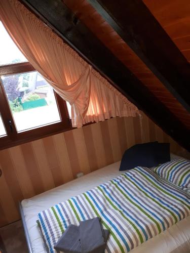 a bed in a small room with a window at Feriendorf Freilingen 151 A in Blankenheim