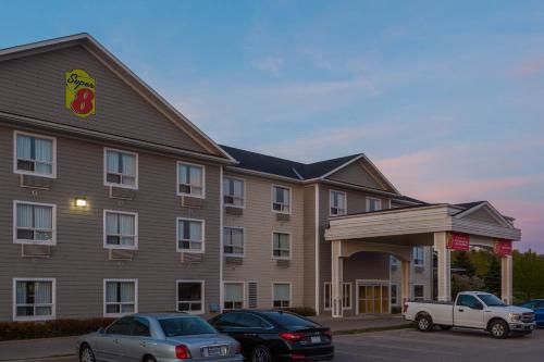 a hotel with cars parked in a parking lot at Super 8 by Wyndham Midland in Midland