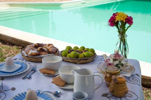 a table with a tray of food and a vase of flowers at Casa Go'El in Chiaramonte Gulfi