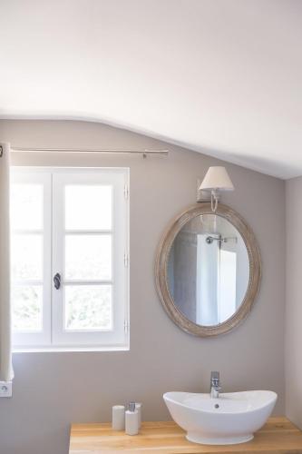 a bathroom with a sink and a mirror at Le Mas des Alexandrins in Uzès