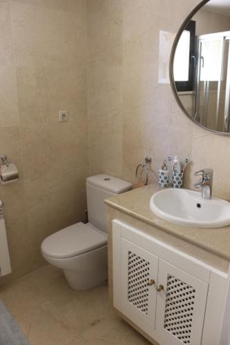 łazienka z toaletą, umywalką i lustrem w obiekcie Roda Golf & Beach Resort, Murcia w mieście Roda