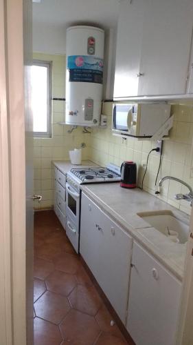 a kitchen with a sink and a stove top oven at Apart frente al mar piso 32 cochera in Mar del Plata