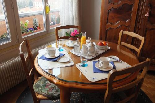 una mesa de comedor con un juego de mesa para el desayuno en Chambre d'hôtes - Garibaldi, en Lyon