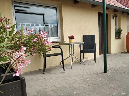 UmmanzにあるFerienwohnung Reiterのパティオ(椅子2脚、テーブル、窓付)