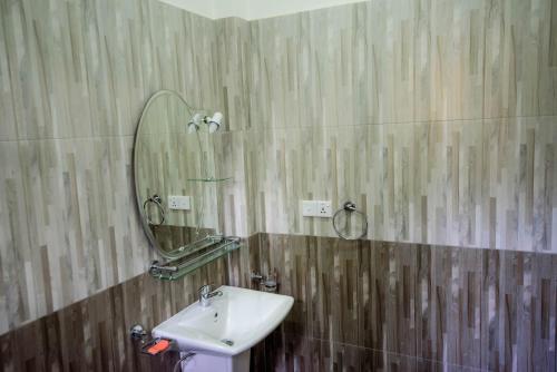 a bathroom with a sink and a mirror on the wall at Halcyon Rest in Hikkaduwa