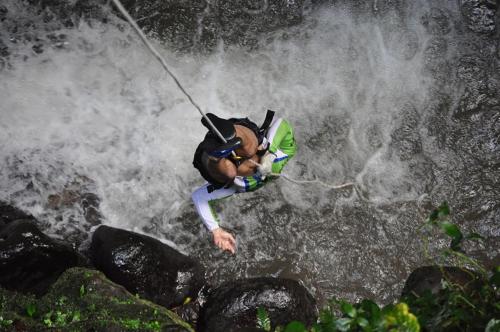 un hombre está en medio de una cascada en Hostel Orozco - Costa Rica, en Río Cuarto