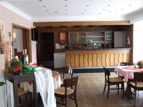 a restaurant with tables and chairs and a bar at Hotel Rose in Georgsmarienhütte