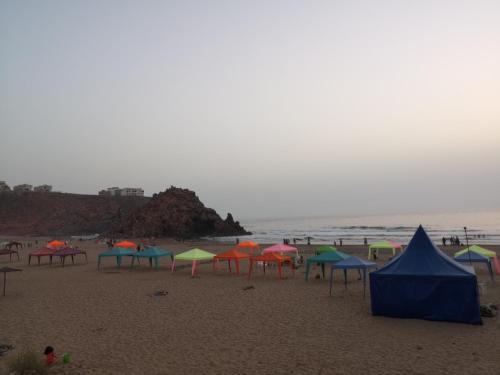 a beach with many colorful umbrellas on the sand at My Home Mirelft in Mirleft