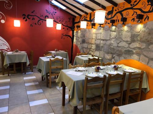 ein Restaurant mit Tischen und Stühlen und einer Steinmauer in der Unterkunft Hostal Teatro Inka in Cusco