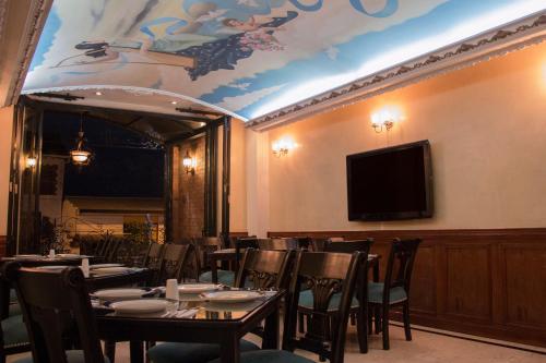 comedor con mesas y sillas y TV de pantalla plana en Hotel Castilla Real en Pereira