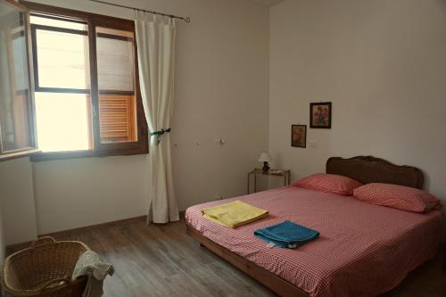 a bedroom with a bed with red sheets and a window at La Quercia Agriturismo in Imperia