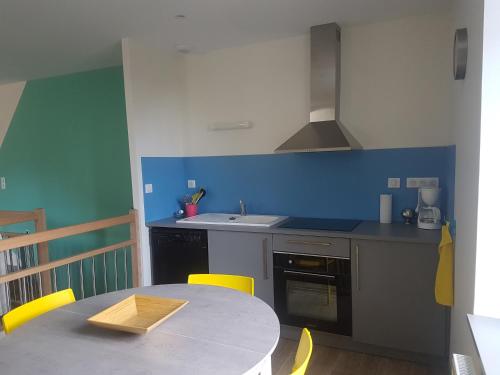 Una pequeña cocina con una mesa y un fregadero. en Gite Saint Nicolas, en Paray-le-Monial