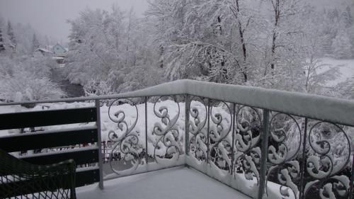 a balcony covered in snow with a bench at Riverview apartment Three Springs Tri Zvira in Zamost