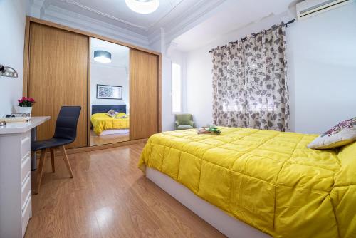 バレンシアにあるConfortable Apartamento * La Marina de Valenciaのベッドルーム(黄色いベッド1台、デスク付)