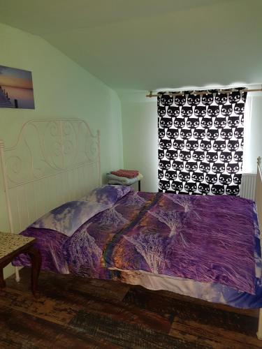 a bedroom with a bed with a purple comforter and a window at Old Centrum Bucharest in Bucharest