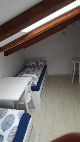 a small room with two beds and a table at Istrian Sunrise in Koper