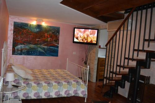 a bedroom with a bed and a tv on the wall at Casa Paradiso in Chieti