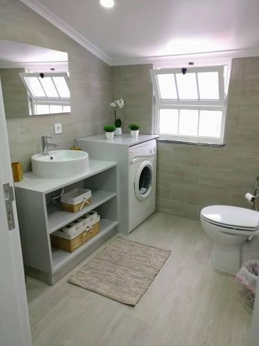 a bathroom with a washing machine and a sink at Casa do Relógio in Horta