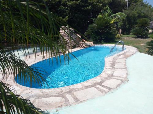 a swimming pool with blue water in a yard at B&B Leonida in Taranto