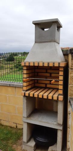a outdoor oven sitting next to a brick wall at Apartamentos Casa Carmen in Suances