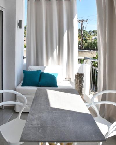 a living room with a couch and a table and chairs at Angelos Boutique Suites in Patitiri