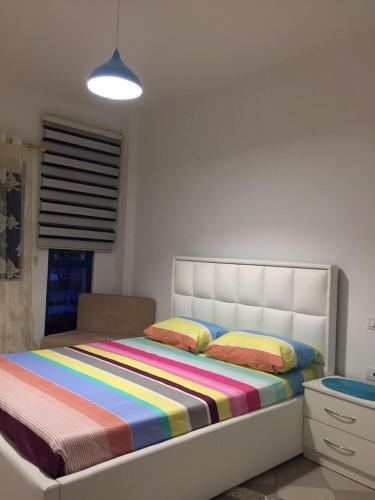 a bedroom with a bed with a colorful striped blanket at Lovely Apartment in Golem