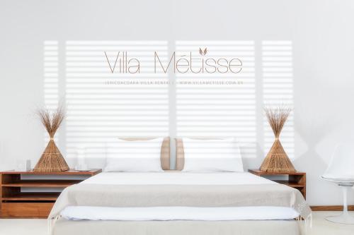 a white bedroom with a white bed with a vita mattress sign at Villa Métisse in Jericoacoara