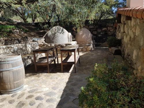 a patio with a table and chairs and a stone wall at El Molino de Cachi in Cachí