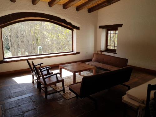 a living room with a couch and a table and a window at El Molino de Cachi in Cachí