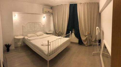 a bedroom with a white bed with white pillows at Green Apartment 59 in Bucharest