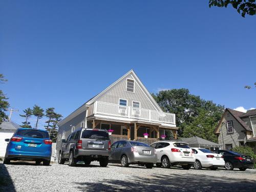 a group of cars parked in front of a house at Pine View Lodge Old Orchard Beach in Old Orchard Beach