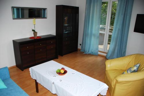 a living room with a table with a bowl of fruit on it at Kasztanowa Apartament in Warsaw