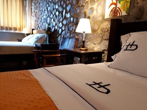 a hotel room with a bed and a table with a lamp at Ecohotel Bordones in Isnos