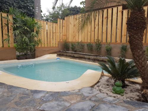 a swimming pool in a backyard with a wooden fence at Casa Boutique QX- Pachacamac in Pachacamac
