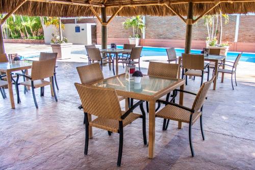 a group of tables and chairs under a umbrella at Hotel Maioris Navolato in San Pedro