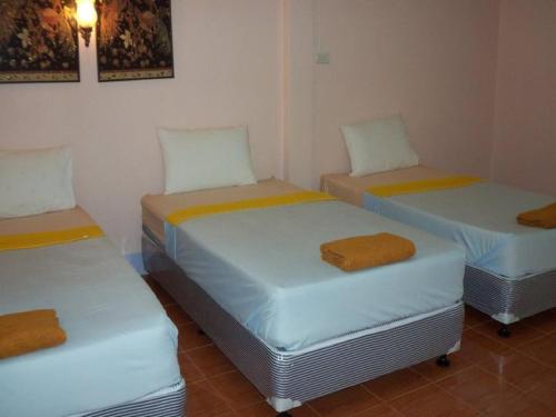 a room with three beds with towels on them at D's Corner & Guesthouse in Phuket Town