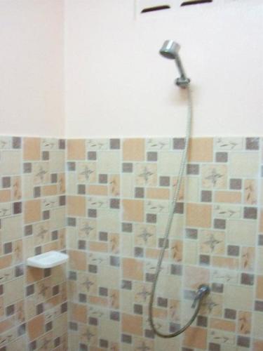 a shower in a bathroom with a shower head at D's Corner & Guesthouse in Phuket
