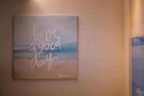 a picture of a sign hanging on a wall at Enoca Hotel in Fujisawa