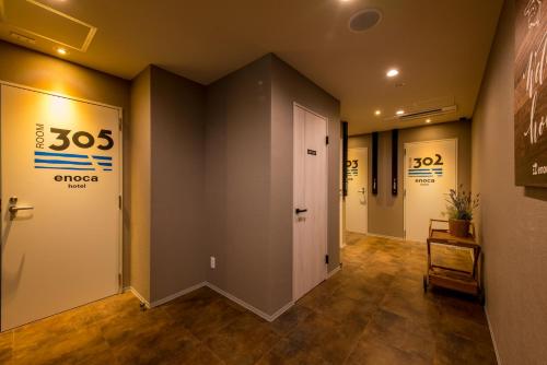 a hallway with doors and signs on the walls at Enoca Hotel in Fujisawa