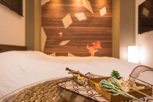 a bed with a wooden headboard and a tray of food at Enoca Hotel in Fujisawa