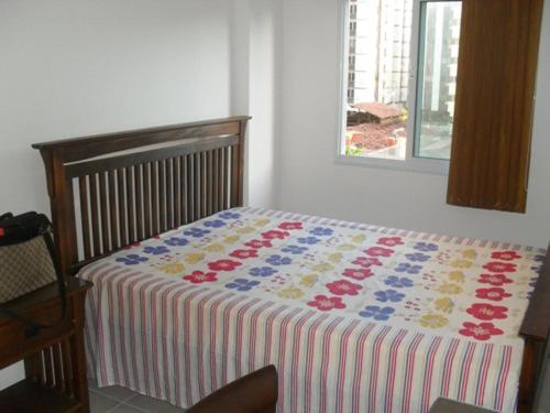 Un dormitorio con una cama con una manta de colores. en Condominio jtr brasil en Maceió