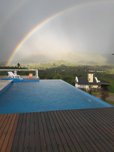 un arco iris sobre una piscina con arco iris en Cabañas Altos del Nagual en Valle Hermoso