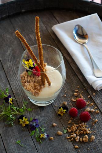 a bowl of cereal and berries on a wooden table at Oaks Cypress Lakes Resort in Pokolbin