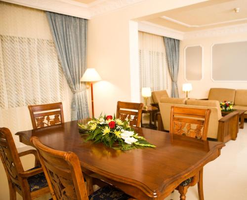 a dining room with a table with flowers on it at Hotel Muscat Holiday in Muscat