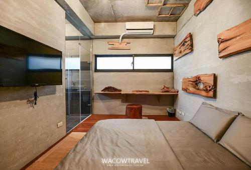 a bedroom with a bed and a tv in a room at Pin Shiuan Inn in Xiaoliuqiu