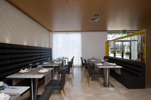 a dining room with tables and chairs and a window at Hotel Briganti in Qualiano